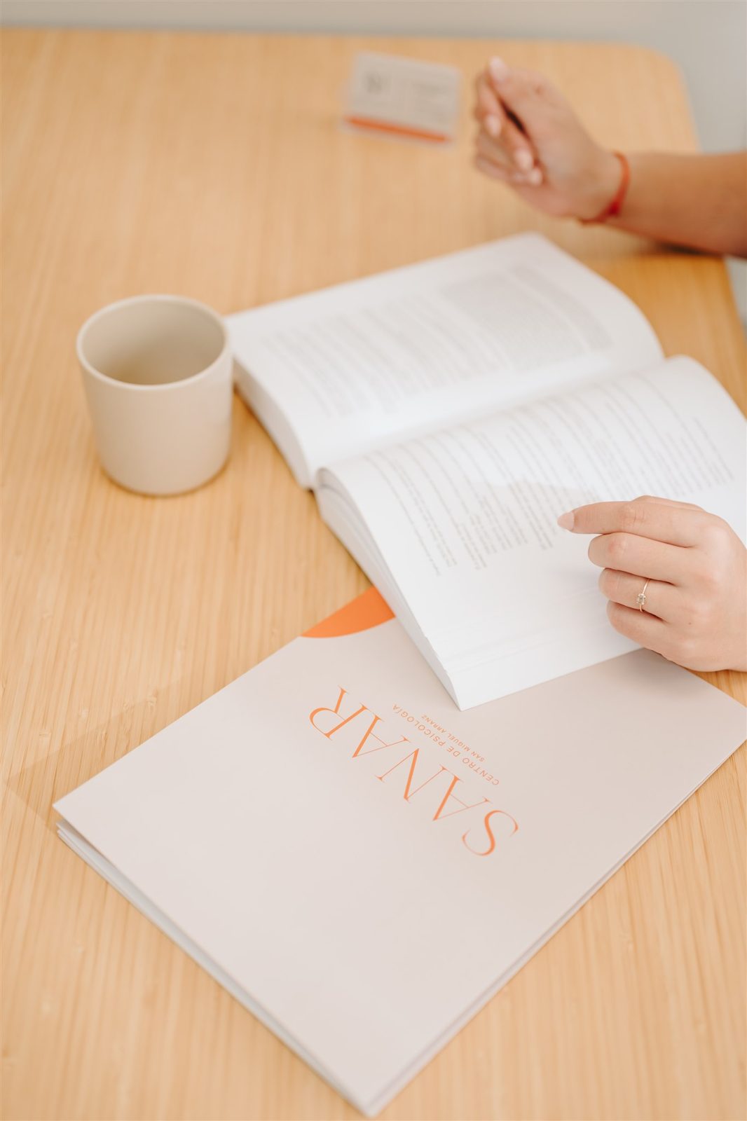 Libro abierto y taza en la consulta de terapia para adultos de Sanar Psicología en Valladolid